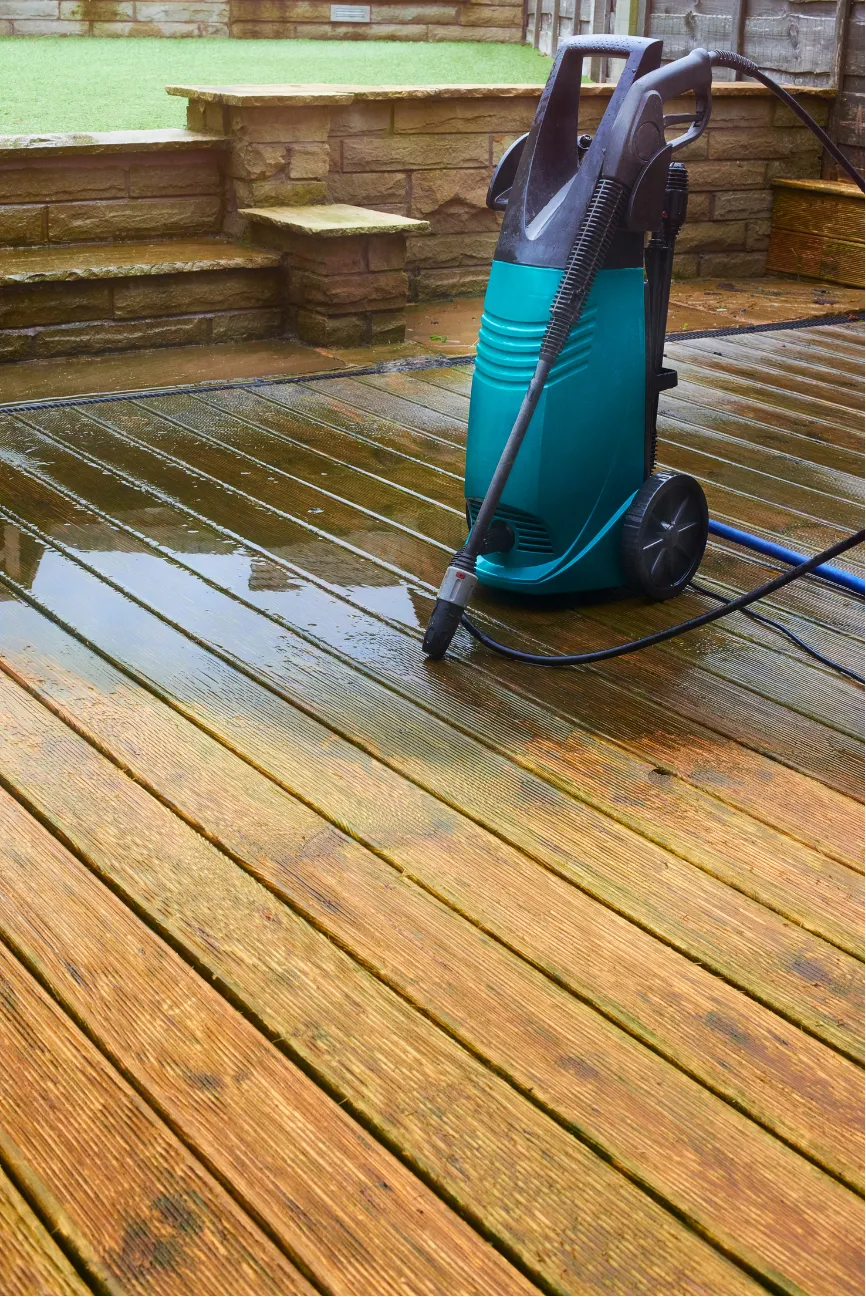 pressure-washing-w Pressure washer on wooden decking with water residue; stone steps in the background.